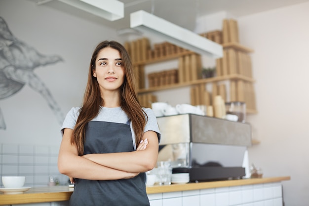 Porträt des selbstbewussten weiblichen Cafébesitzers, der erfolgreiches Geschäft mitten in der geschäftigen Stadt führt.