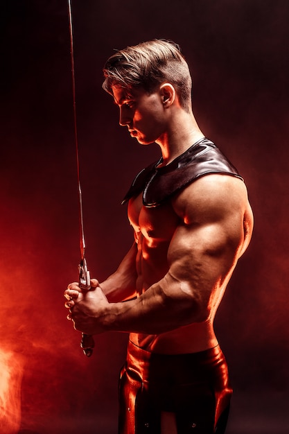 Porträt des sexy muskulösen starken Mannes, der Klinge hält.