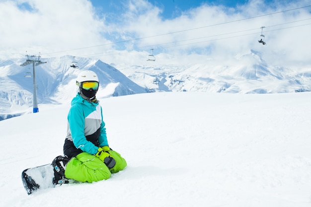 Porträt des Snowboarders auf der Landschaft der schneebedeckten hohen Berge