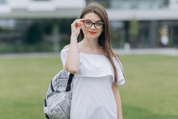 Porträt des Studentenjugendlichmädchens draußen aufwerfend in der Universität