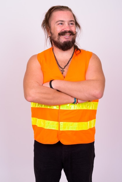 Porträt des übergewichtigen bärtigen Bauarbeiters mit Schnurrbart und langen Haaren gegen weiße Wand