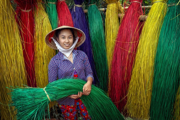 Porträt des vietnamesischen weiblichen Handwerkers, der traditionelle Vietnam-Matten trocknet