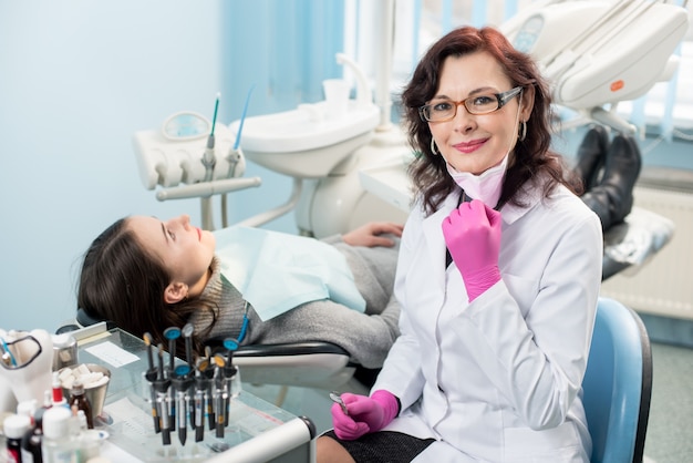 Porträt des Zahnarztes mit Patient im Stuhl