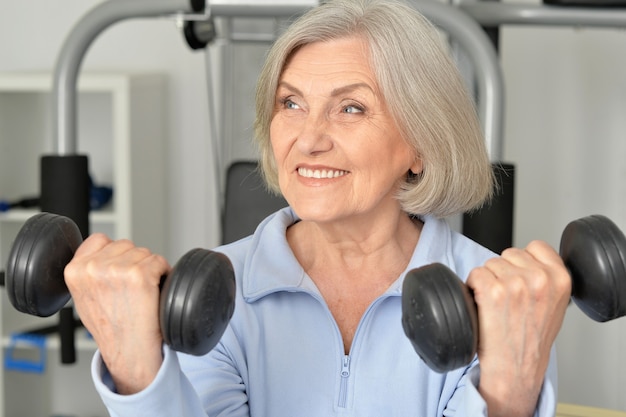 Porträt einer älteren Frau, die im Fitnessstudio trainiert