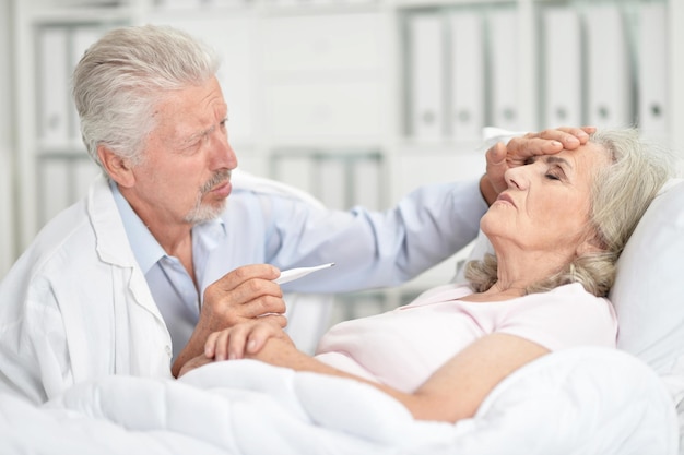 Porträt einer älteren Frau im Krankenhaus mit fürsorglichem Arzt