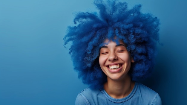 Porträt einer afrikanisch-amerikanischen jungen Frau in Gelegenheitskleidung mit Afro-Frisur auf blauem Hintergrund