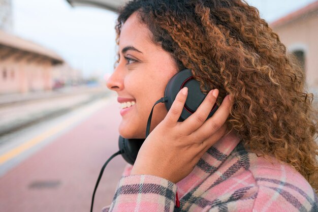 Porträt einer Afro-Frau, die mit Kopfhörern Musik hört