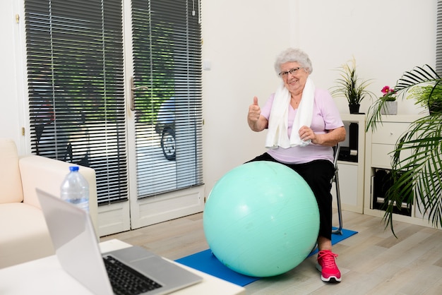 Porträt einer aktiven und dynamischen älteren frau, die zu hause sportfitness macht