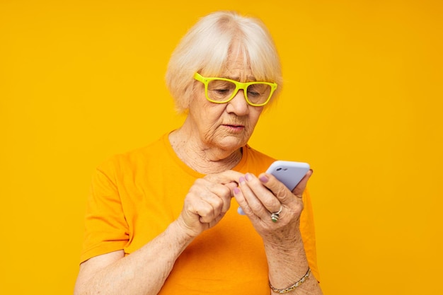 Porträt einer alten freundlichen Frau in lässiger T-Shirt-Kommunikation per Telefontechnologie