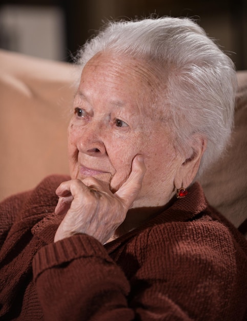 Porträt einer alten grauhaarigen traurigen Frau zu Hause Kranke depressive alte Frau