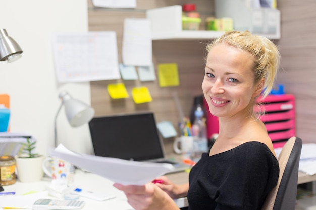 Foto porträt einer an einem tisch arbeitenden frau