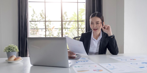 Porträt einer asiatischen Frau, die an einem Tablet-Computer in einem modernen Büro arbeitet Machen Sie einen Kontoanalysebericht über Immobilieninvestitionsinformationen Finanz- und Steuersystemkonzepte