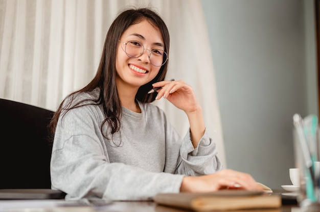 Porträt einer asiatischen Frau, die von zu Hause aus arbeitet, um eine Virusinfektion zu verhindern