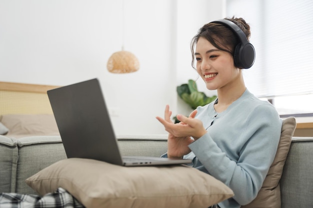 Porträt einer asiatischen Frau, die zu Hause auf dem Sofa sitzt