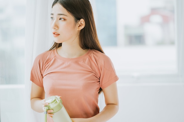 Porträt einer asiatischen Frau, die zu Hause Yoga praktiziert