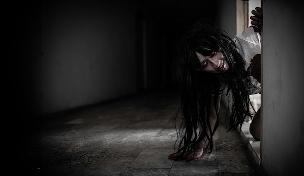 Porträt einer asiatischen Frau macht Geister aus. Schreckliche Horrorszene als Hintergrund. Halloween-Festival-Konzept. Geisterfilme. Wütender Geist in der Wohnung.