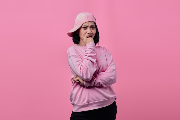 Porträt einer asiatischen Frau mit rosa Hut und Jacke, die mit verführerischem Gesichtsausdruck in die Kamera schaut