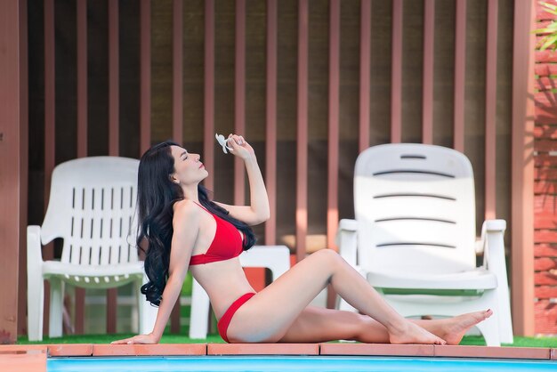 Porträt einer asiatischen sexy Frau am Swimmingpool Thailand hat eine schlanke KörperformGesundes FrauenkonzeptModebikinisommer