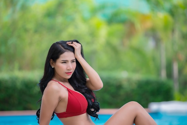 Porträt einer asiatischen sexy Frau am Swimmingpool Thailand hat eine schlanke KörperformGesundes FrauenkonzeptModebikinisommer