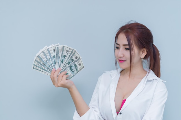 Porträt einer asiatischen sexy Frau mit viel Geld auf weißem Hintergrund. Thailänder. Das Konzept der reichen Geschäftsfrau