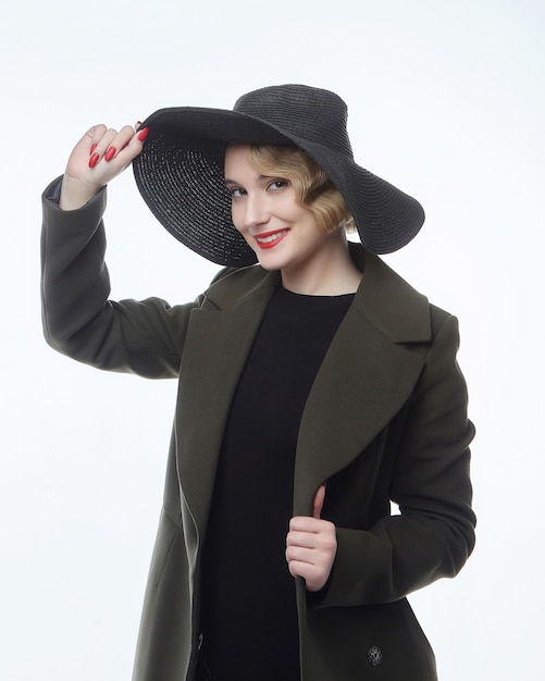 Porträt einer attraktiven Blondine mit einer Retro-Frisur in einem schwarzen Hut mit einer breiten Krempe