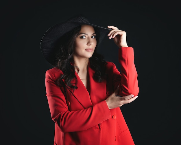 Porträt einer attraktiven Frau in einer roten Jacke und einem Hut