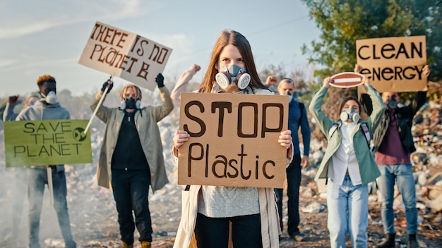 Porträt einer attraktiven jungen Aktivistin mit einem Plakat, das dazu aufruft, Plastik zu stoppen