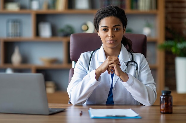 Porträt einer attraktiven schwarzen Ärztin, die in der Klinik posiert