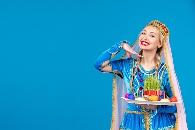 Porträt einer azerinischen Frau in traditioneller Kleidung mit Novruz Xonca blauem Hintergrund Frühlingsfarben ethnische Geldtänzerin