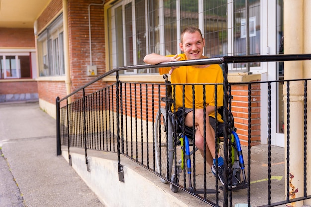Porträt einer behinderten person, die in einem rollstuhl in der schule gelb gekleidet ist und lächelt