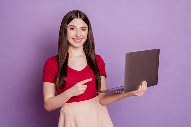 Porträt einer Beraterin, die ein Netbook-Direkt-Finger-Werbegerät auf violettem Hintergrund hält