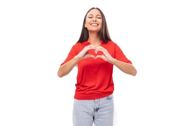 Porträt einer bezaubernden, süßen jungen europäischen brünetten Dame in einem roten T-Shirt auf weißem Hintergrund mit