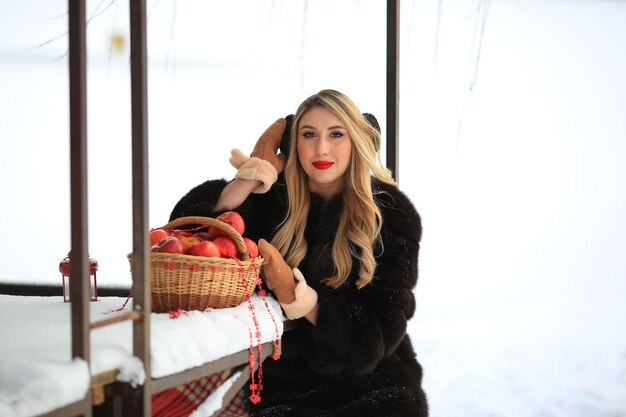 Porträt einer Blondine mit rotem Lippenstift im Winter im Dezember Schwarzer Pelzmantel