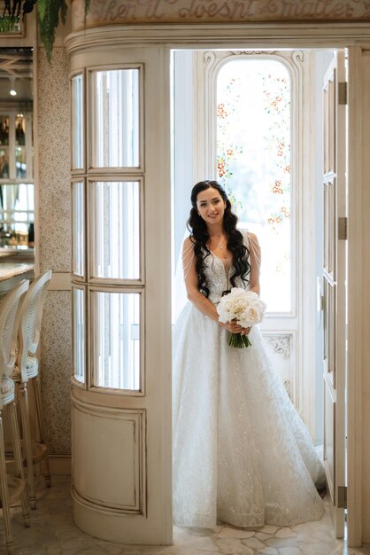 Porträt einer Braut in einem weißen Kleid in einem hellen Café