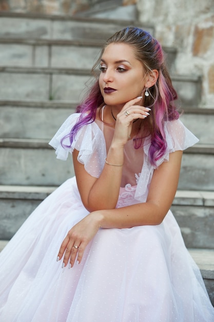 Porträt einer Braut mit purpurroter Haarnahaufnahme. Eine Frau in einem schönen Kleid ruht sich aus