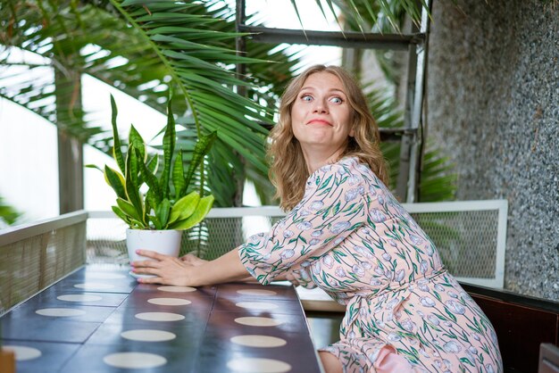 Foto porträt einer charmanten frau, die in ihrer freizeit allein in einem café sitzt