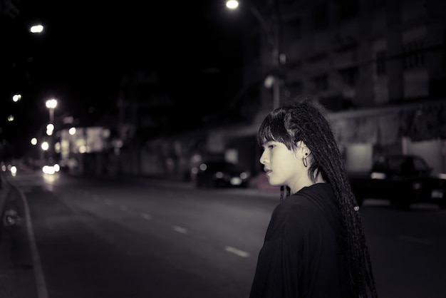 Porträt einer einsamen Frau mit Dreadlocks Nachtszene in der StadtTraurige Frau Konzeptthailand Menschen