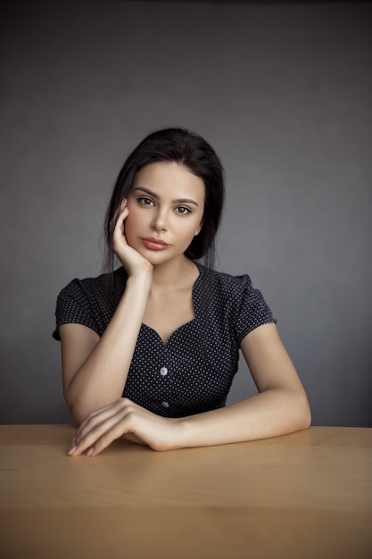 Porträt einer eleganten Frau, die drinnen sitzt