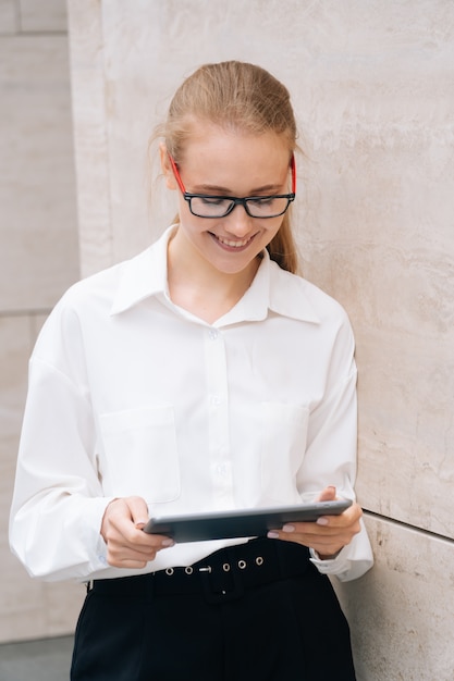 Porträt einer eleganten fröhlichen lächelnden Geschäftsfrau, die Brille trägt