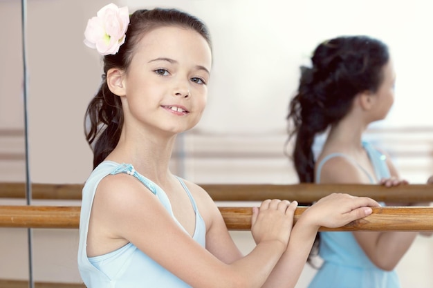 Porträt einer entzückenden Ballerina, die mit einer Barre posiert