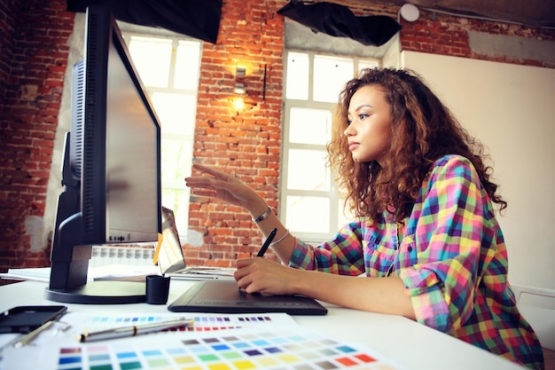 Porträt einer ernsthaften Geschäftsfrau mit Laptop im Büro Schöne Hipsterfrau macht Notizen in einem modernen Büro