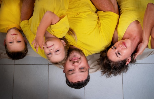 Foto porträt einer familie, die auf den kopf liegt