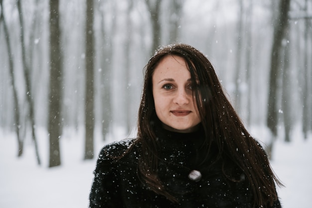 Porträt einer Frau auf dem Hintergrund eines verschneiten Waldes