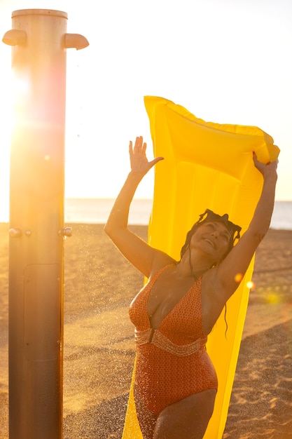 Foto porträt einer frau, die am strand duscht