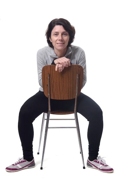 Porträt einer Frau, die auf einem Stuhl im weißen Hintergrund sitzt