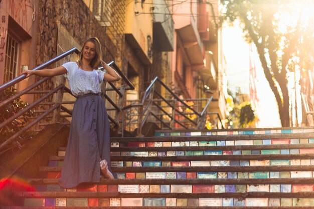 Porträt einer Frau, die auf Stufen gegen ein Gebäude in der Stadt steht