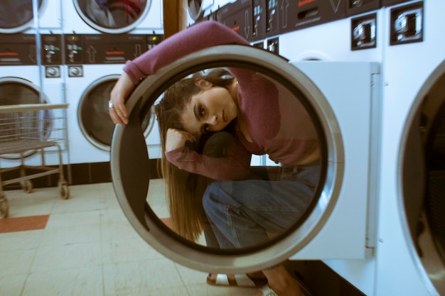 Porträt einer Frau, die durch die Tür eines Waschsalons schaut