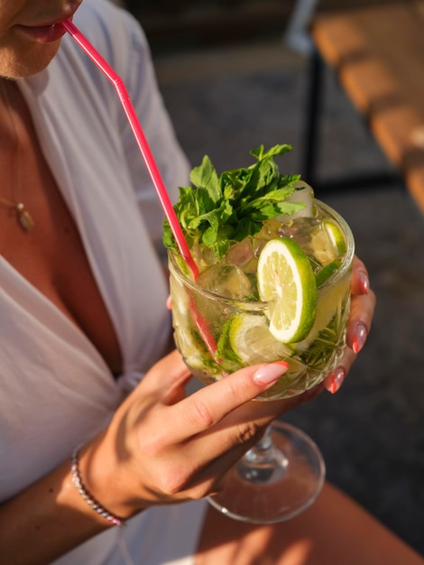 Porträt einer Frau, die einen großen Mojito trinkt