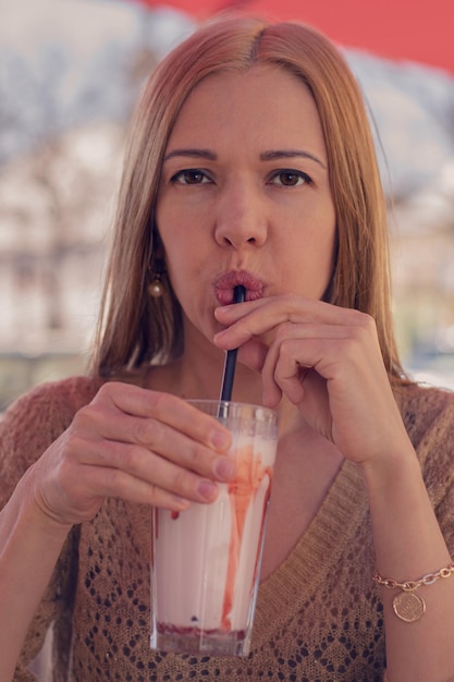 Foto porträt einer frau, die einen smoothie im café trinkt