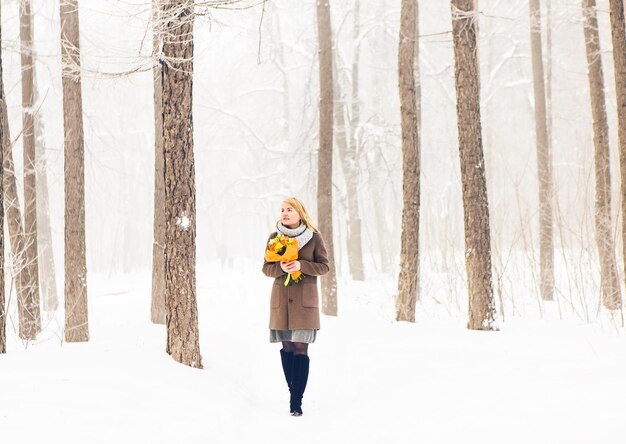 Porträt einer Frau, die im schneebedeckten Wald steht